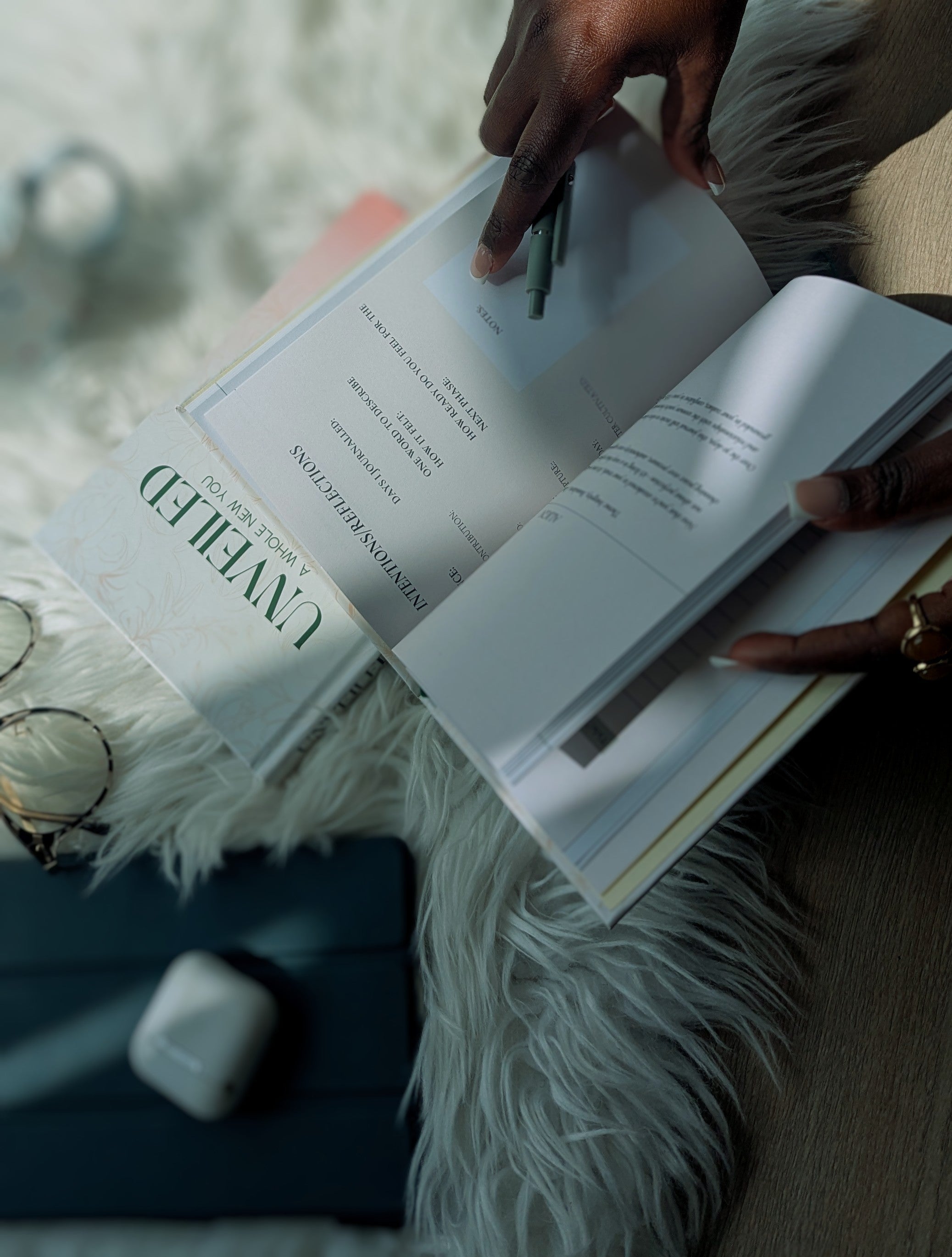 Yemi Ayodeji flipping through the unveiled journal with a blurred background